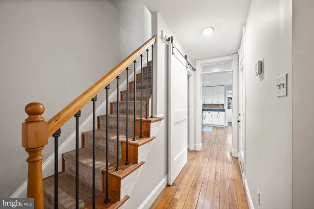 a view of hallway with wooden floor and stairs