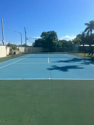 a view of a swimming pool with a lawn chairs and floor to ceiling window