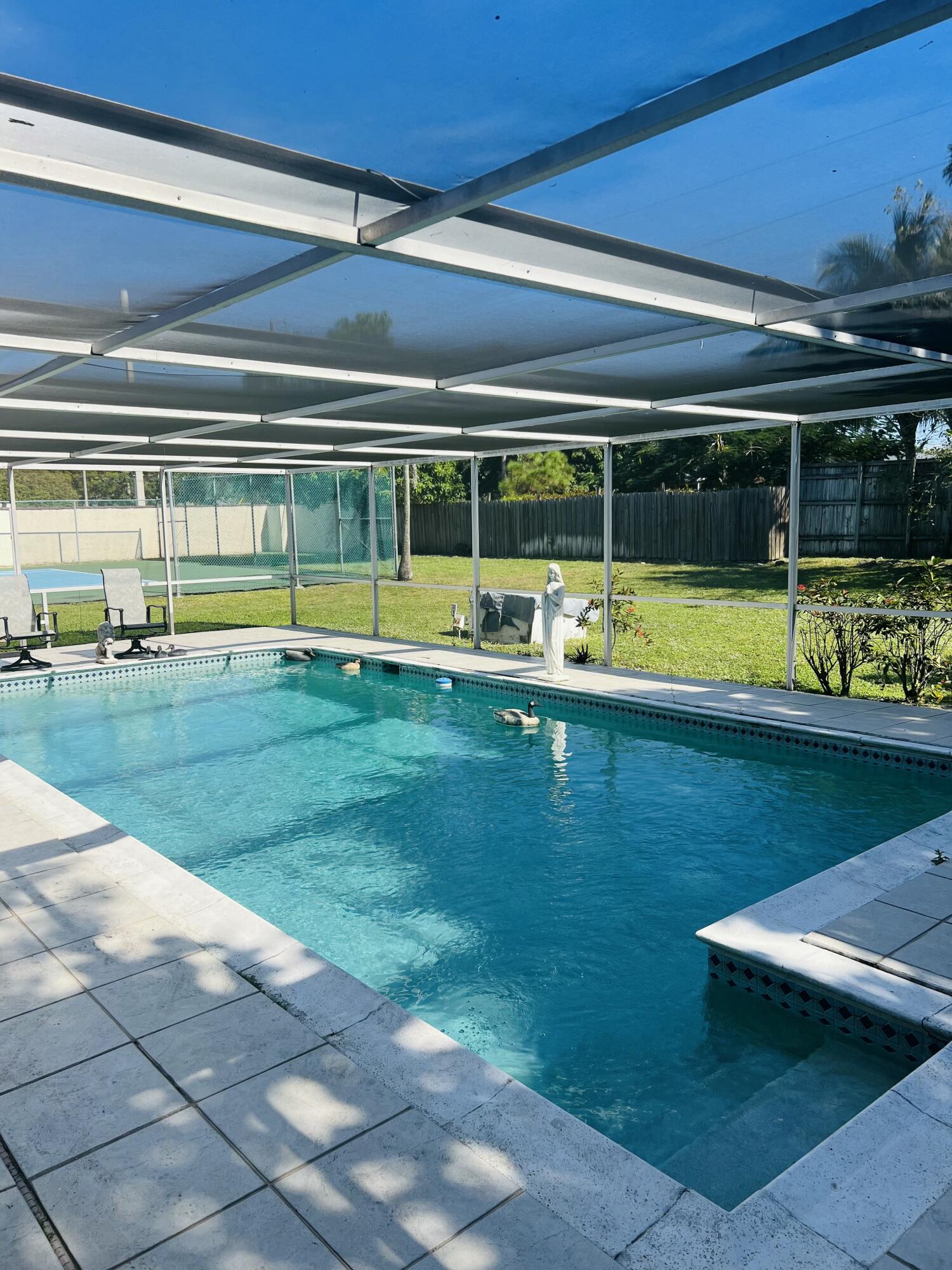 1270 Northwest 4th Avenue Boca Raton, FL 33432 - Photo 8 of 11 a view of a swimming pool with a lawn chairs and floor to ceiling window