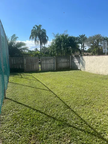 a view of a big yard with swimming pool and green space