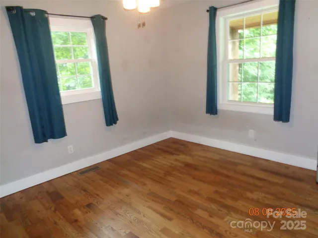 a view of a livingroom with wooden floor and stairs