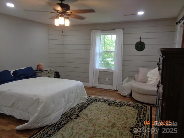 a spacious bedroom with a bed and a flat screen television