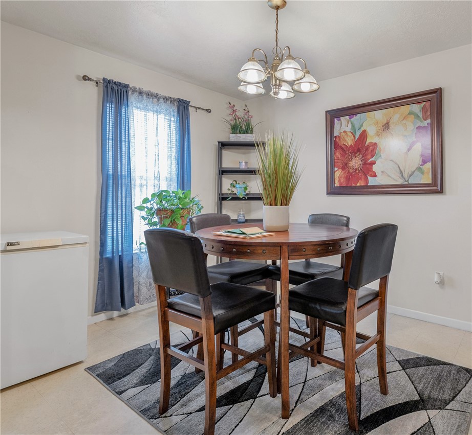 1009 West 17th Street Bryan, TX 77803 - Photo 5 of 11 a dining room with furniture a rug and a chandelier