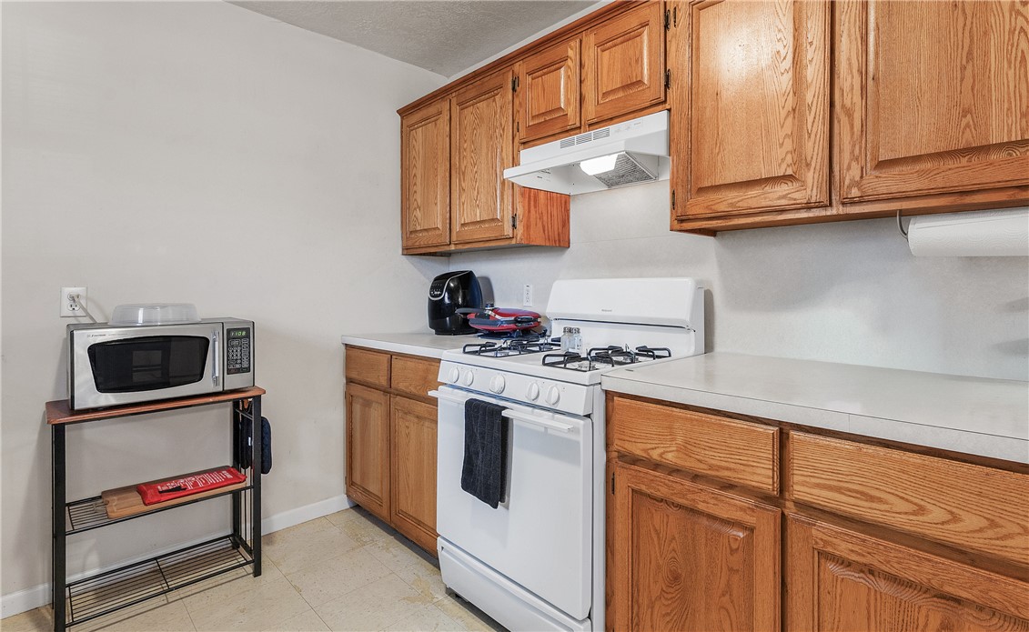 1009 West 17th Street Bryan, TX 77803 - Photo 7 of 11 a kitchen with stainless steel appliances granite countertop a stove microwave and sink