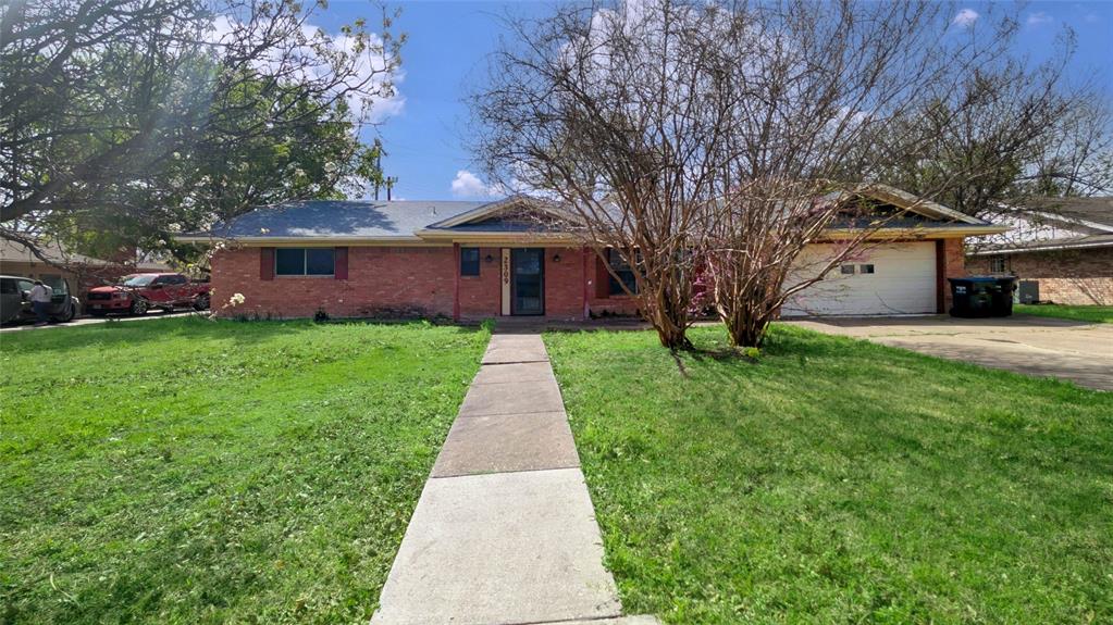 a front view of a house with a yard and trees