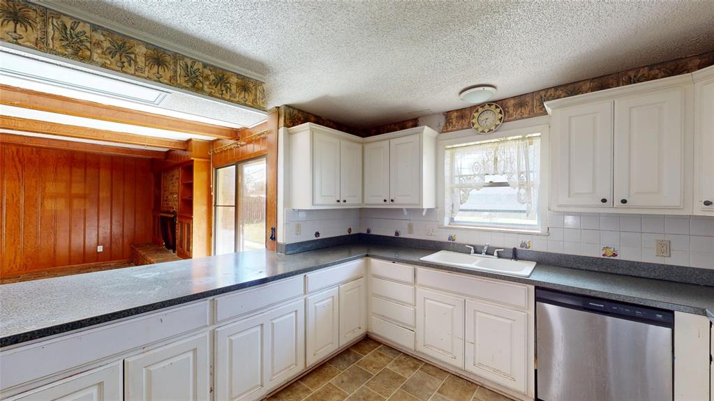 2309 Terrell Road Greenville, TX 75402 - Photo 11 of 30 a kitchen with granite countertop a sink cabinets window and stainless steel appliances