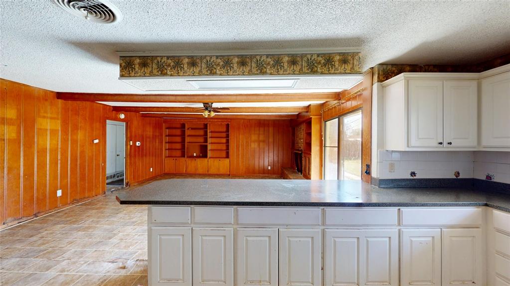 2309 Terrell Road Greenville, TX 75402 - Photo 12 of 30 a kitchen with a cabinets and chandelier