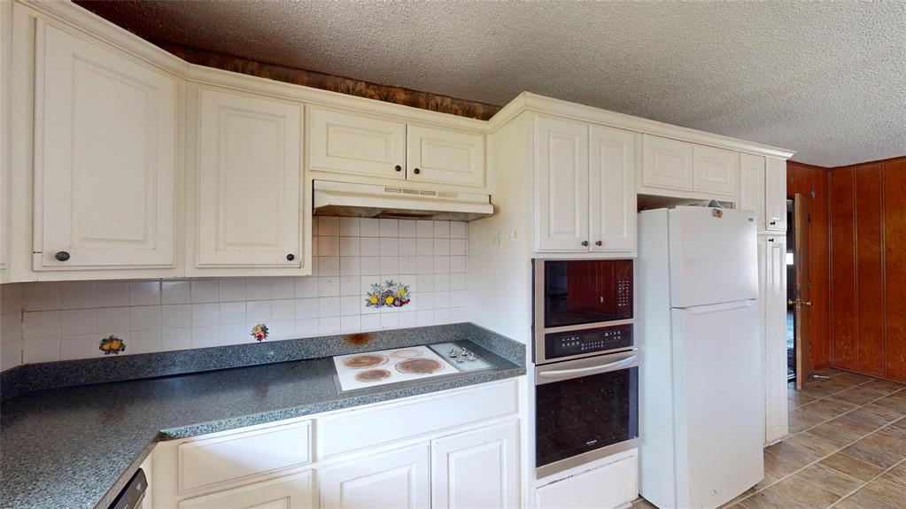2309 Terrell Road Greenville, TX 75402 - Photo 13 of 30 a kitchen with stainless steel appliances a stove a refrigerator and cabinets