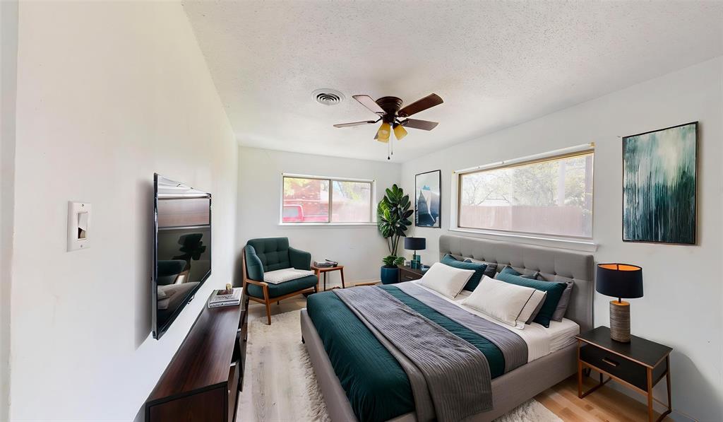 2309 Terrell Road Greenville, TX 75402 - Photo 19 of 30 a bedroom with a bed and wooden floor