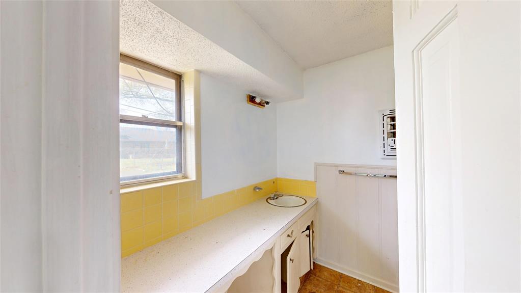2309 Terrell Road Greenville, TX 75402 - Photo 21 of 30 a bathroom with a sink a toilet and a window