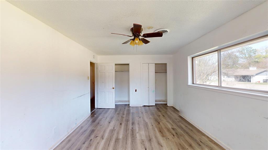 2309 Terrell Road Greenville, TX 75402 - Photo 24 of 30 a view of a room with a wooden floor and a ceiling fan