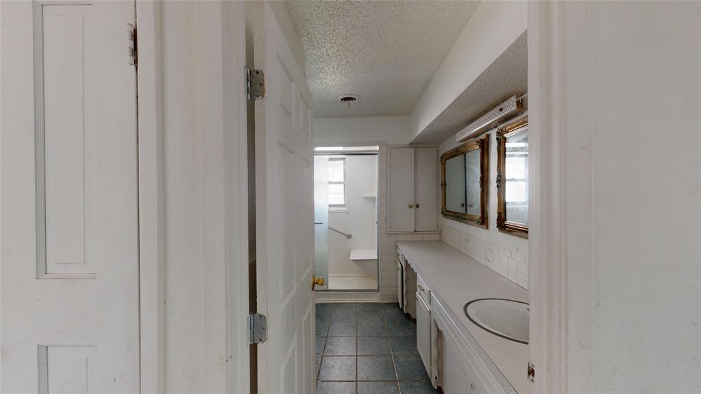 2309 Terrell Road Greenville, TX 75402 - Photo 28 of 30 a bathroom with a toilet a sink and mirror