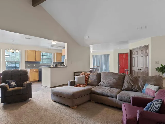 a living room with furniture and kitchen view
