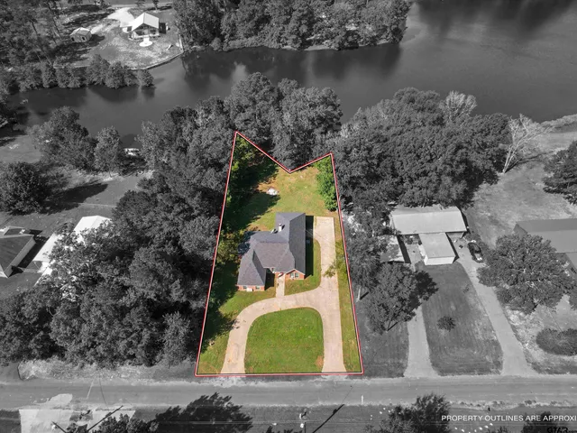 an aerial view of a house with a yard and lake view
