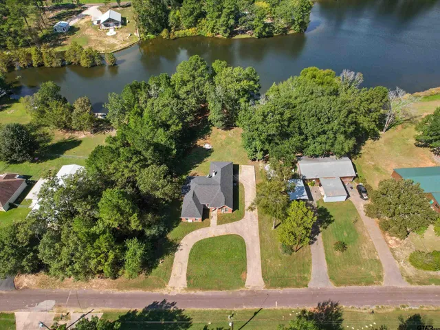 an aerial view of a house with a yard and lake view