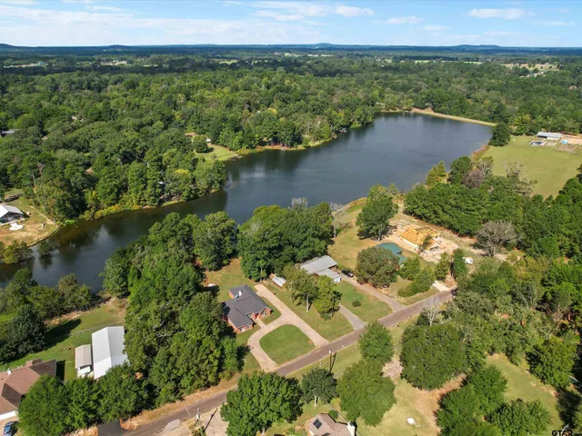 an aerial view of a house with a yard and lake view