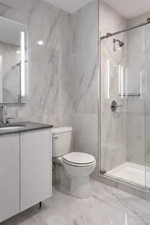 a bathroom with a granite countertop sink toilet and shower
