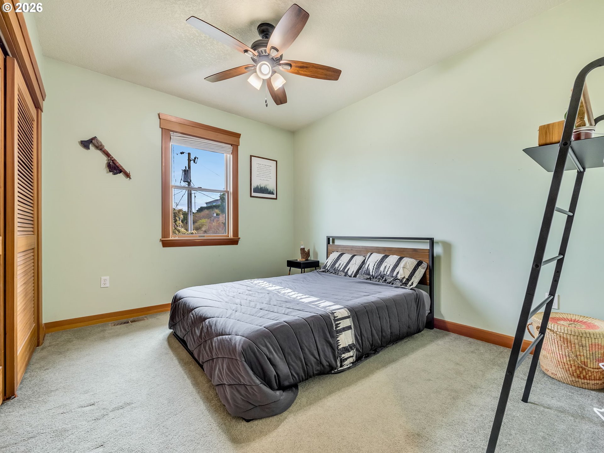 409 2nd Street Astoria, OR 97103 - Photo 28 of 45 a bedroom with a bed and a chandelier