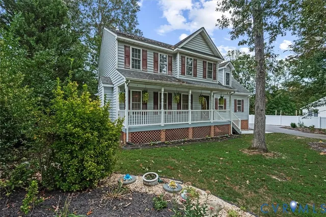 a view of a house with a yard and a large tree in it
