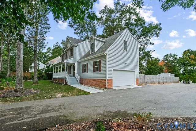 a view of a house with a yard and large tree