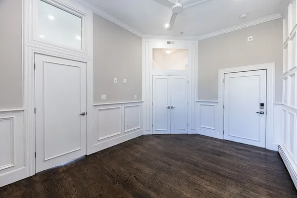 an empty room with wooden floor & closet area