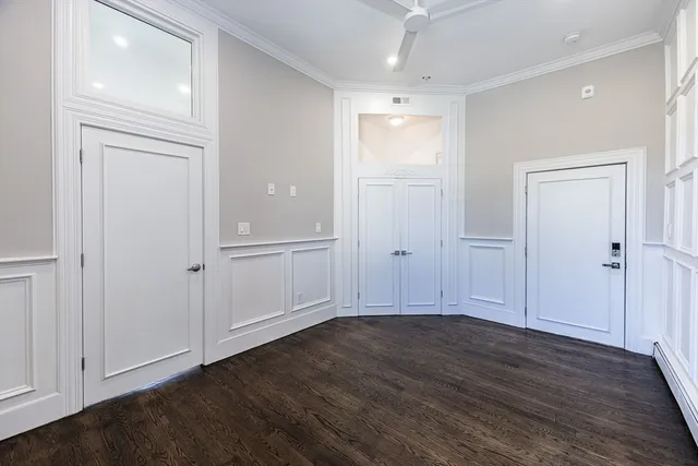 an empty room with wooden floor & closet area
