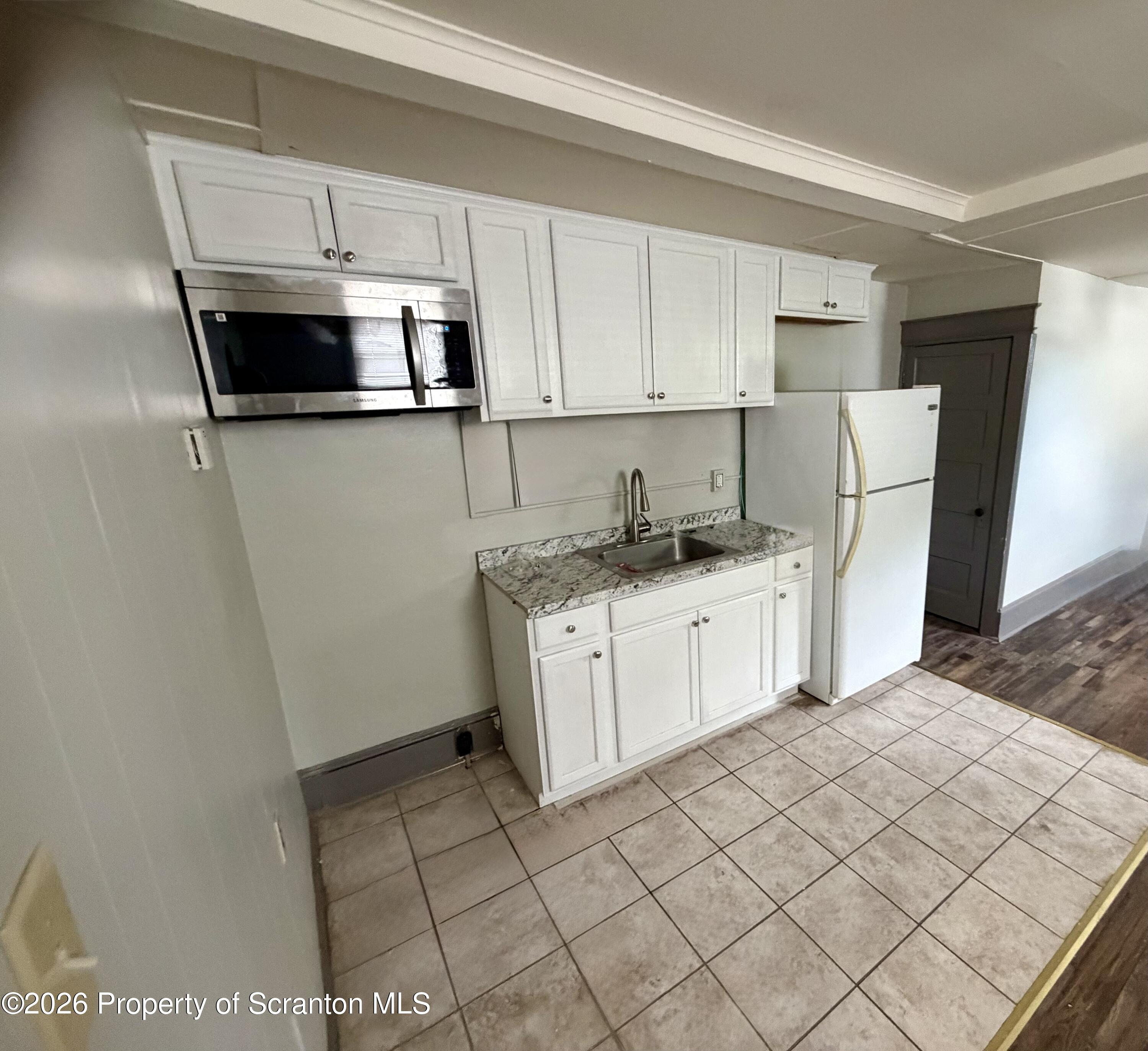 130 State Street, Unit 1 Nanticoke, PA 18634 - Photo 3 of 7 a kitchen with a sink a microwave and refrigerator