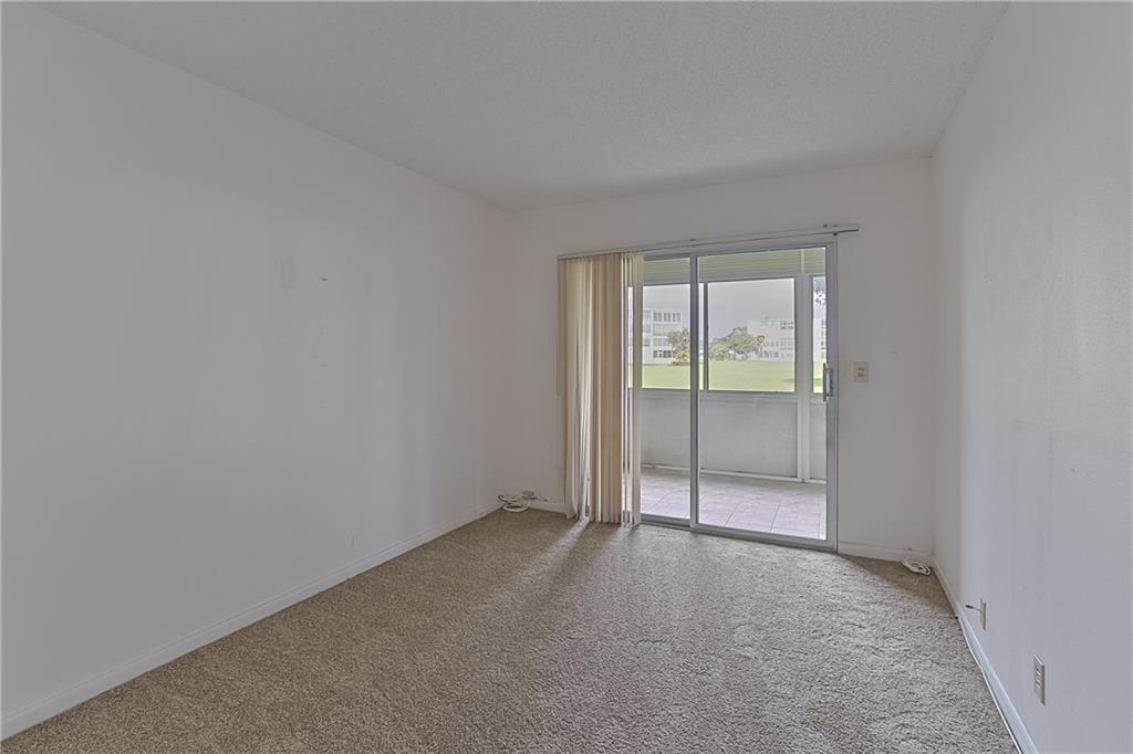 167 Grantham East, Unit 167 Deerfield Beach, FL 33442 - Photo 12 of 20 wooden floor and window in an empty room
