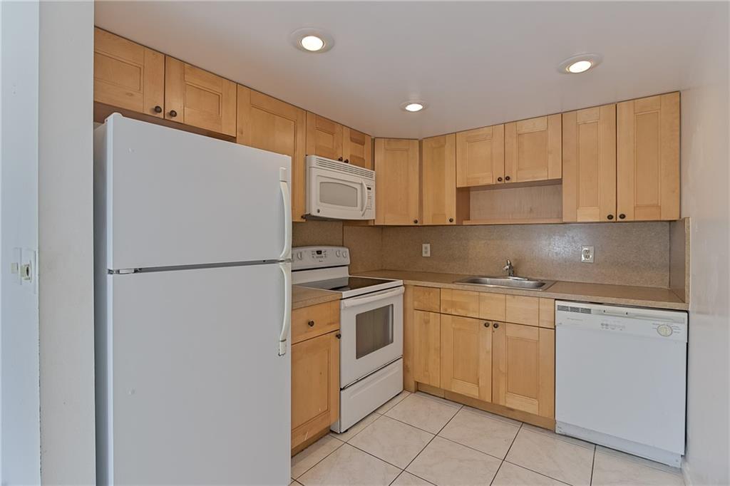 167 Grantham East, Unit 167 Deerfield Beach, FL 33442 - Photo 9 of 20 a kitchen with cabinets stainless steel appliances and a counter top