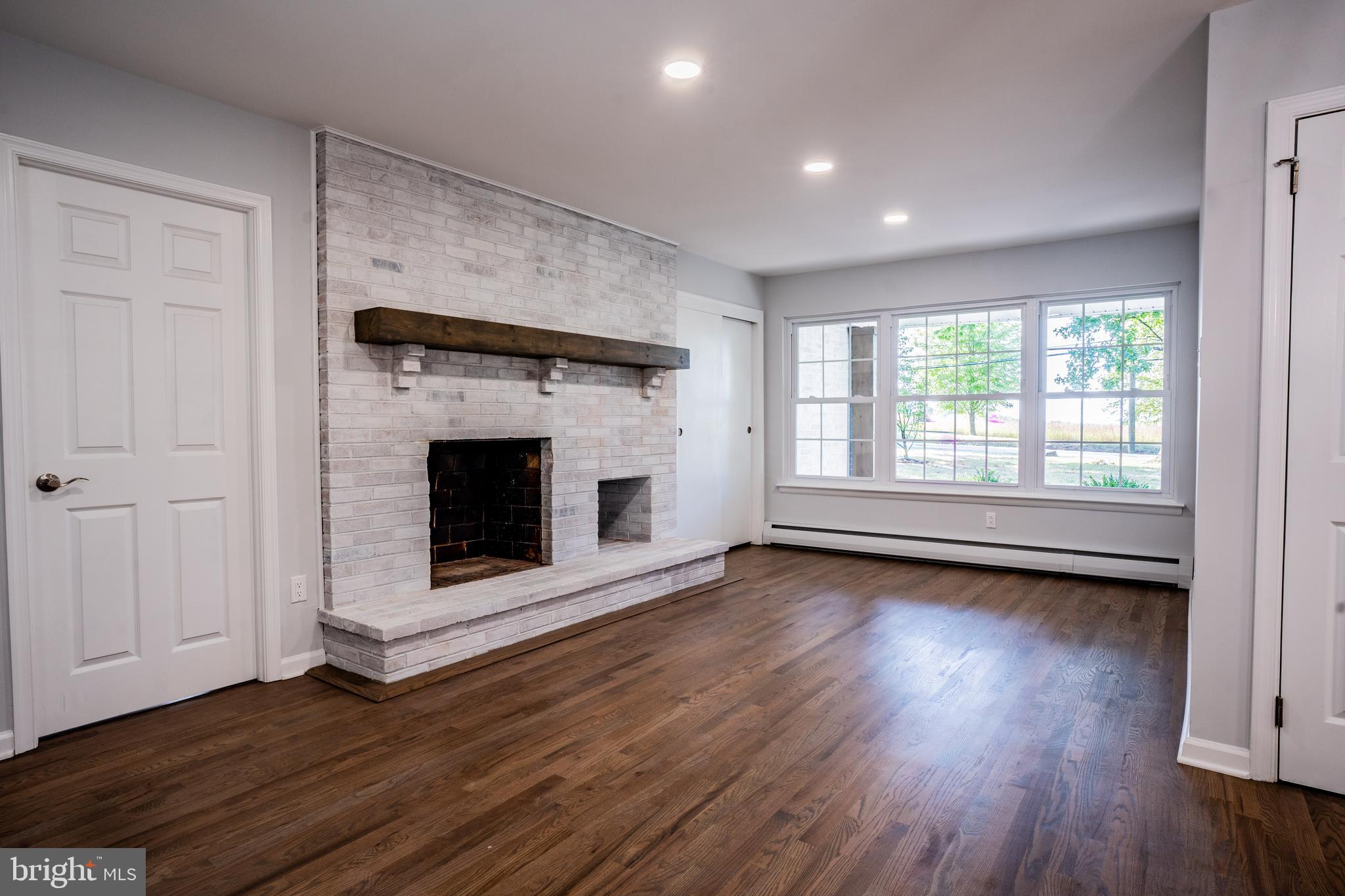 1428 Valley Forge Road Norristown, PA 19403 - Photo 11 of 24 an empty room with wooden floor fireplace and windows