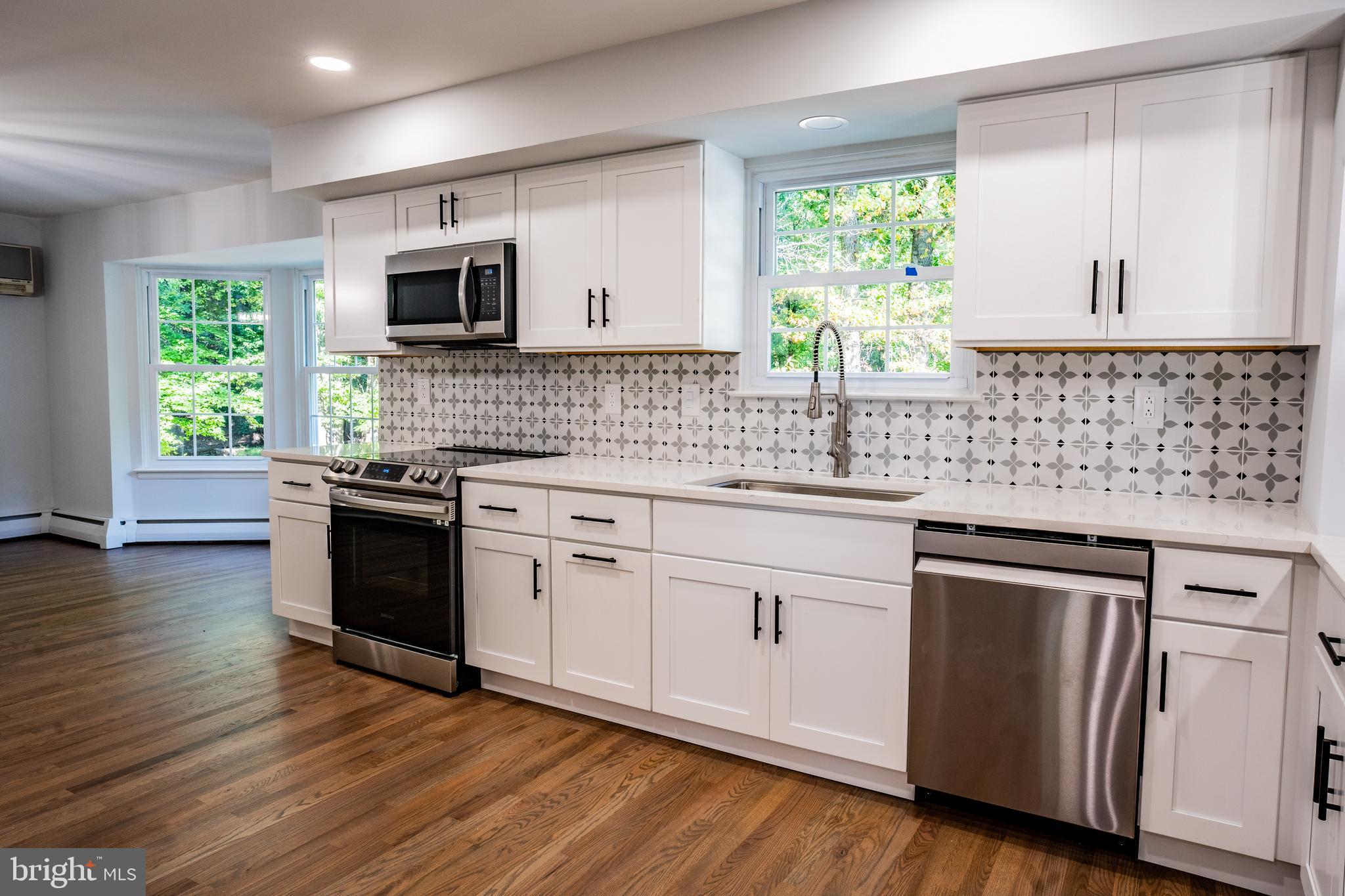 1428 Valley Forge Road Norristown, PA 19403 - Photo 6 of 24 a kitchen with granite countertop white cabinets and wooden floor