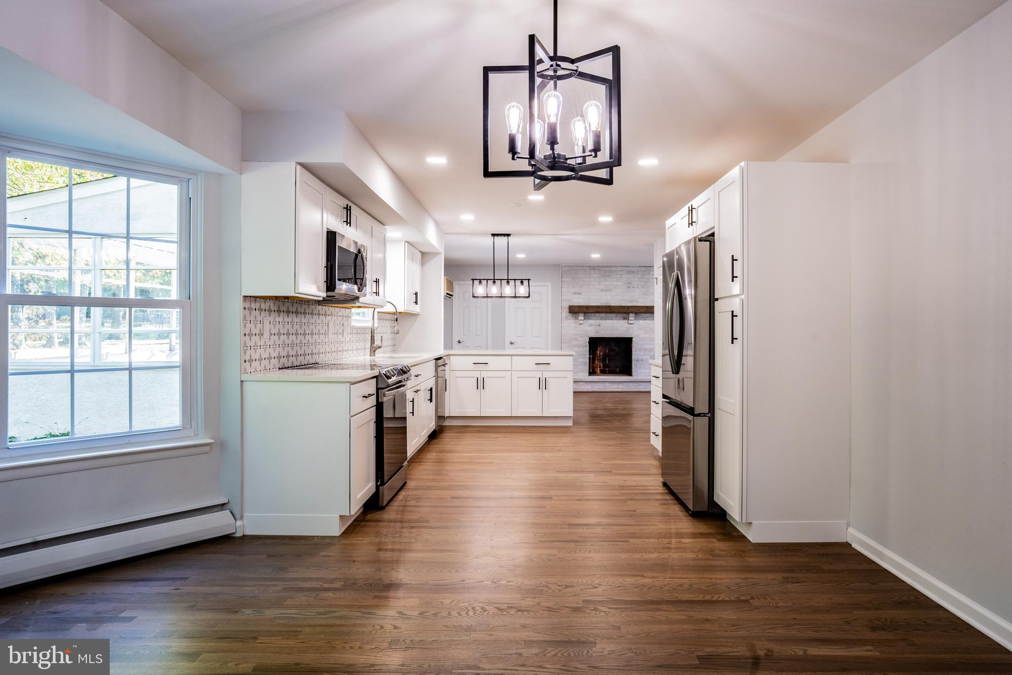 1428 Valley Forge Road Norristown, PA 19403 - Photo 10 of 24 a kitchen with stainless steel appliances a refrigerator a sink dishwasher a stove and white cabinets with wooden floor