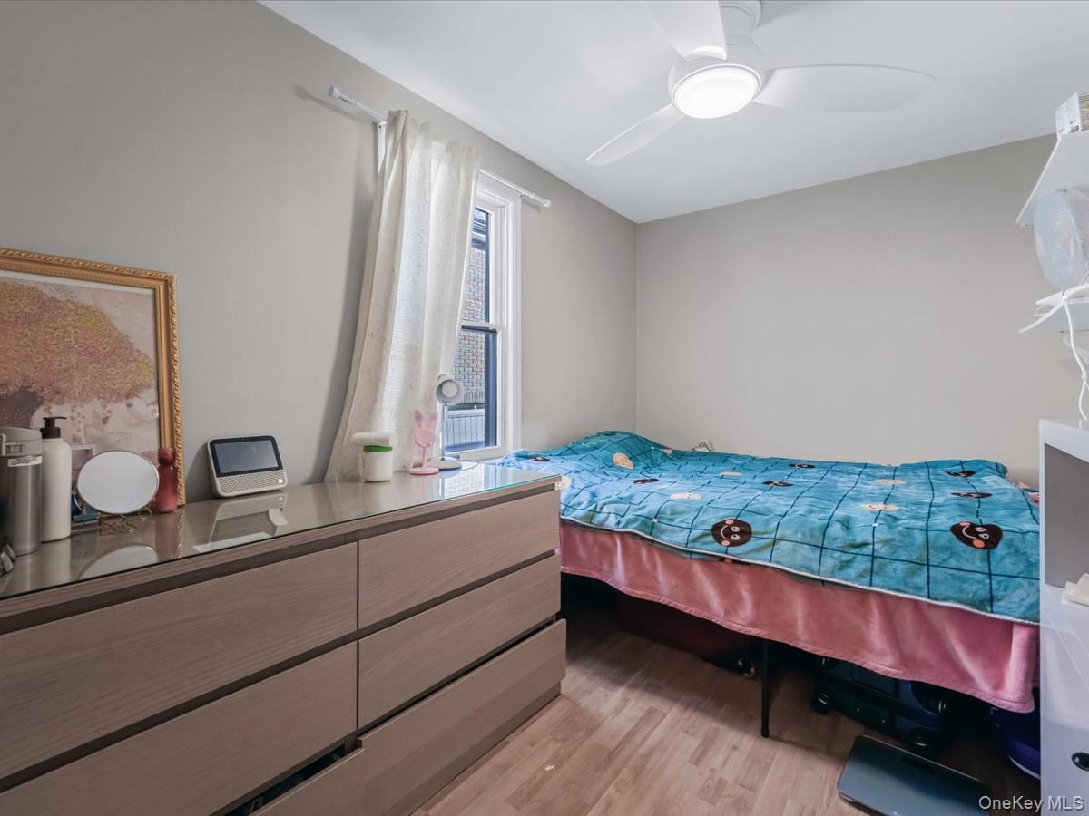 217-32 Corbett Road Queens, NY 11361 - Photo 6 of 25 Bedroom with light wood-style flooring and ceiling fan
