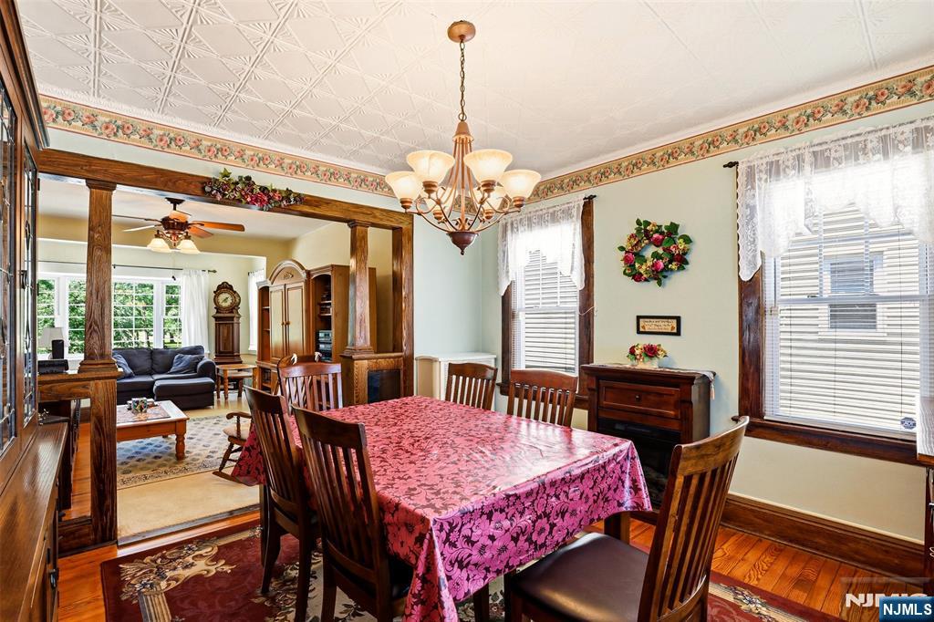 332 Riverside Avenue Lyndhurst, NJ 07071 - Photo 16 of 31 a dining room with wooden floor a chandelier a wooden table and chairs