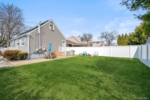 a front view of house with yard and trees in the background