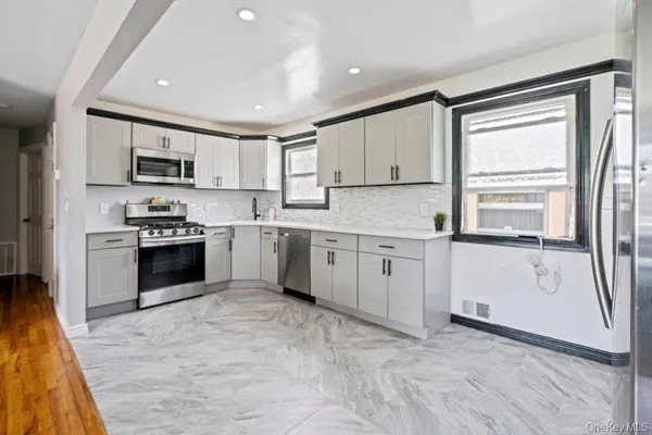 a kitchen with granite countertop white cabinets and white appliances