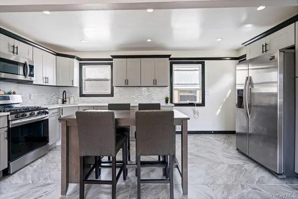a kitchen with stainless steel appliances granite countertop a stove top oven a sink and a refrigerator