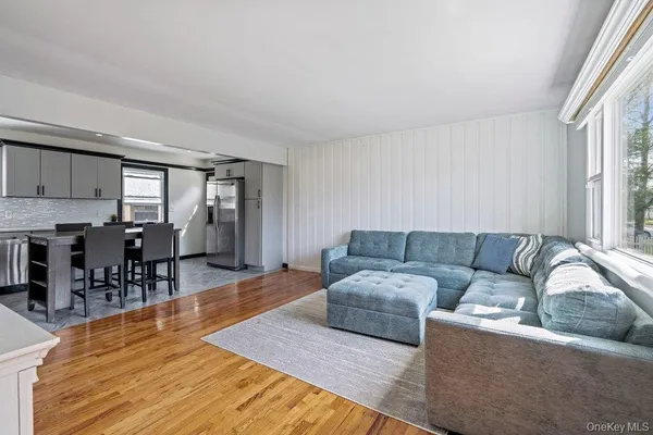 a living room with furniture and a dining table with kitchen view