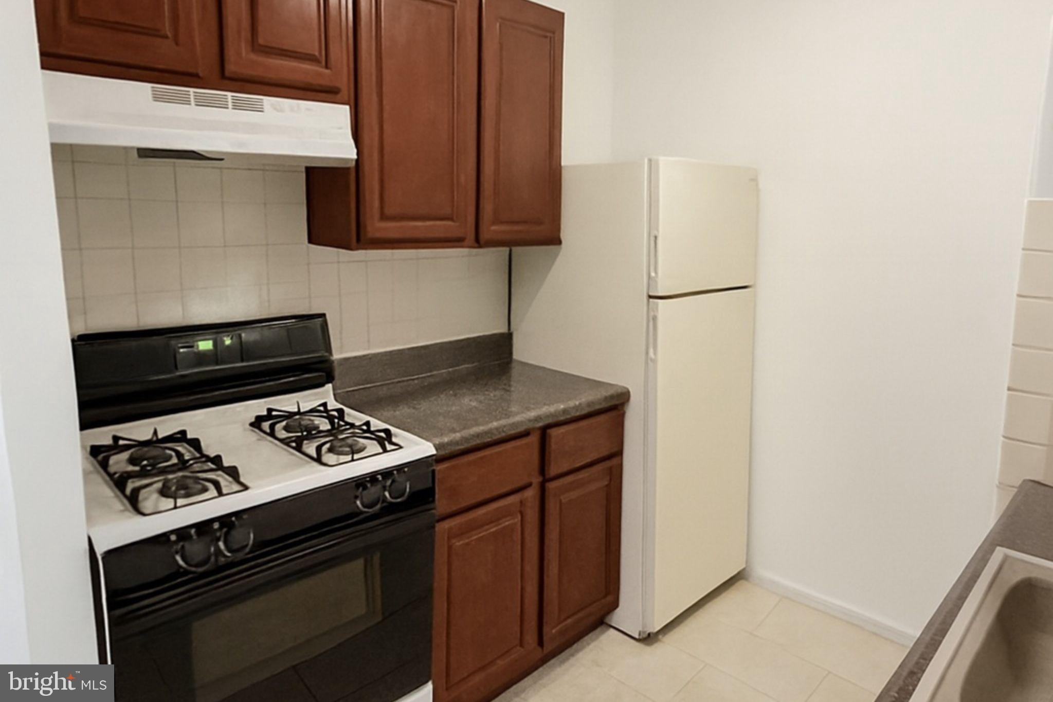 2727 Rhawn Street Philadelphia, PA 19152 - Photo 4 of 10 a kitchen with a stove and a microwave