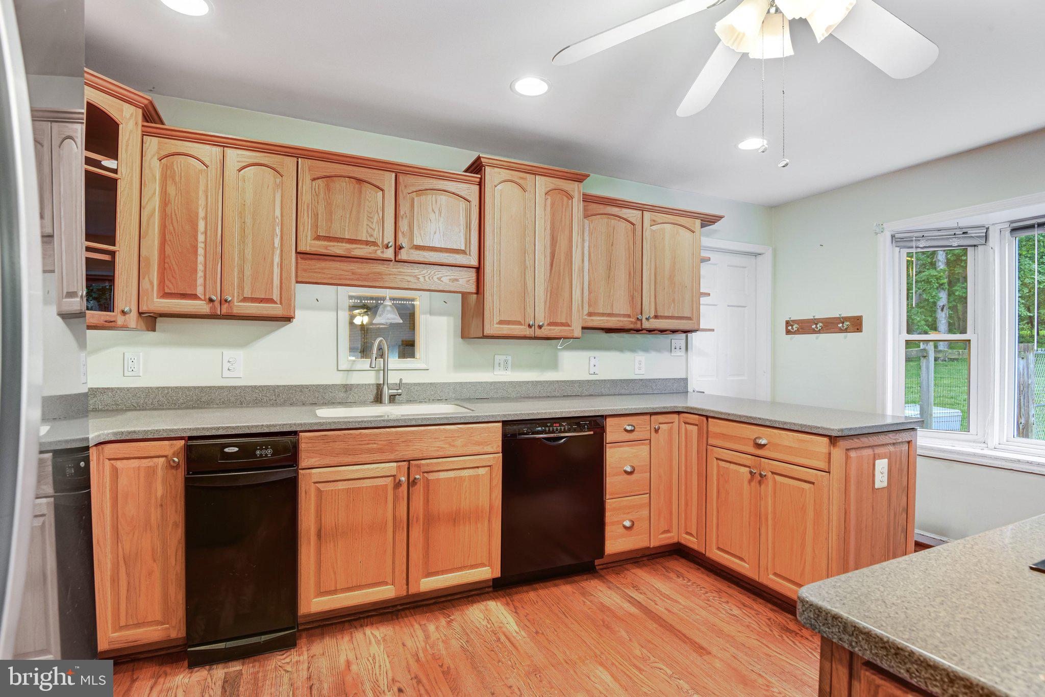 7961 Leeds Manor Road Marshall, VA 20115 - Photo 14 of 40 a kitchen with stainless steel appliances granite countertop wooden cabinets a sink and dishwasher with wooden floor