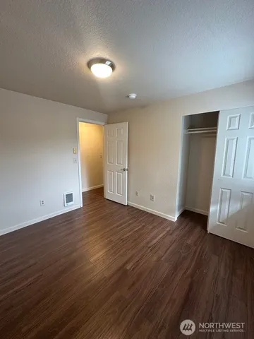 an empty room with wooden floor and door
