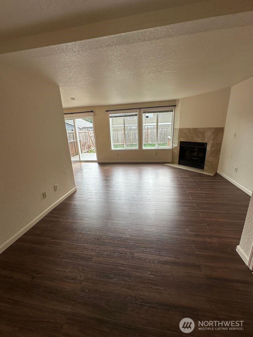 5100 81st Place Southwest, Unit B Mukilteo, WA 98275 - Photo 3 of 12 an empty room with wooden floor and windows