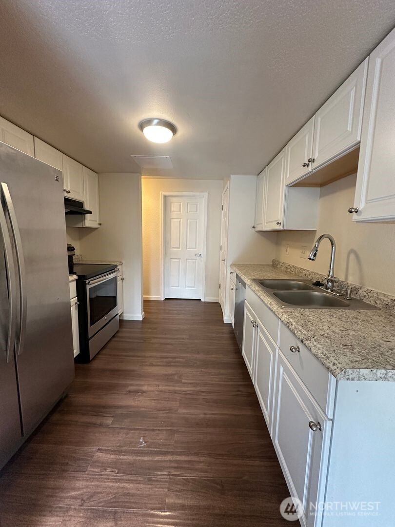 5100 81st Place Southwest, Unit B Mukilteo, WA 98275 - Photo 6 of 12 a large kitchen with granite countertop a large counter top stainless steel appliances and cabinets