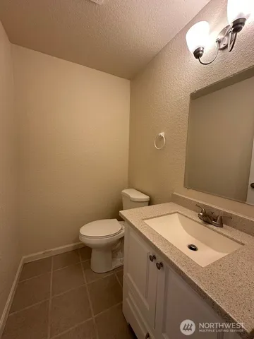 a bathroom with a granite countertop sink a toilet and a mirror