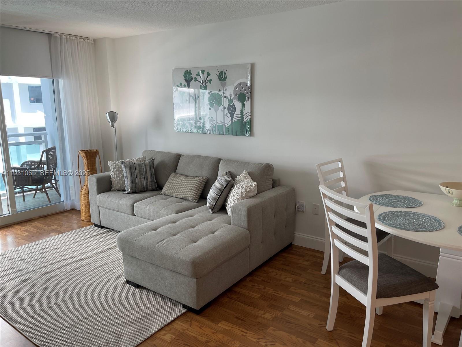 6917 Collins Avenue, Unit 1008 Miami Beach, FL 33141 - Photo 18 of 64 a living room with furniture and a wooden floor