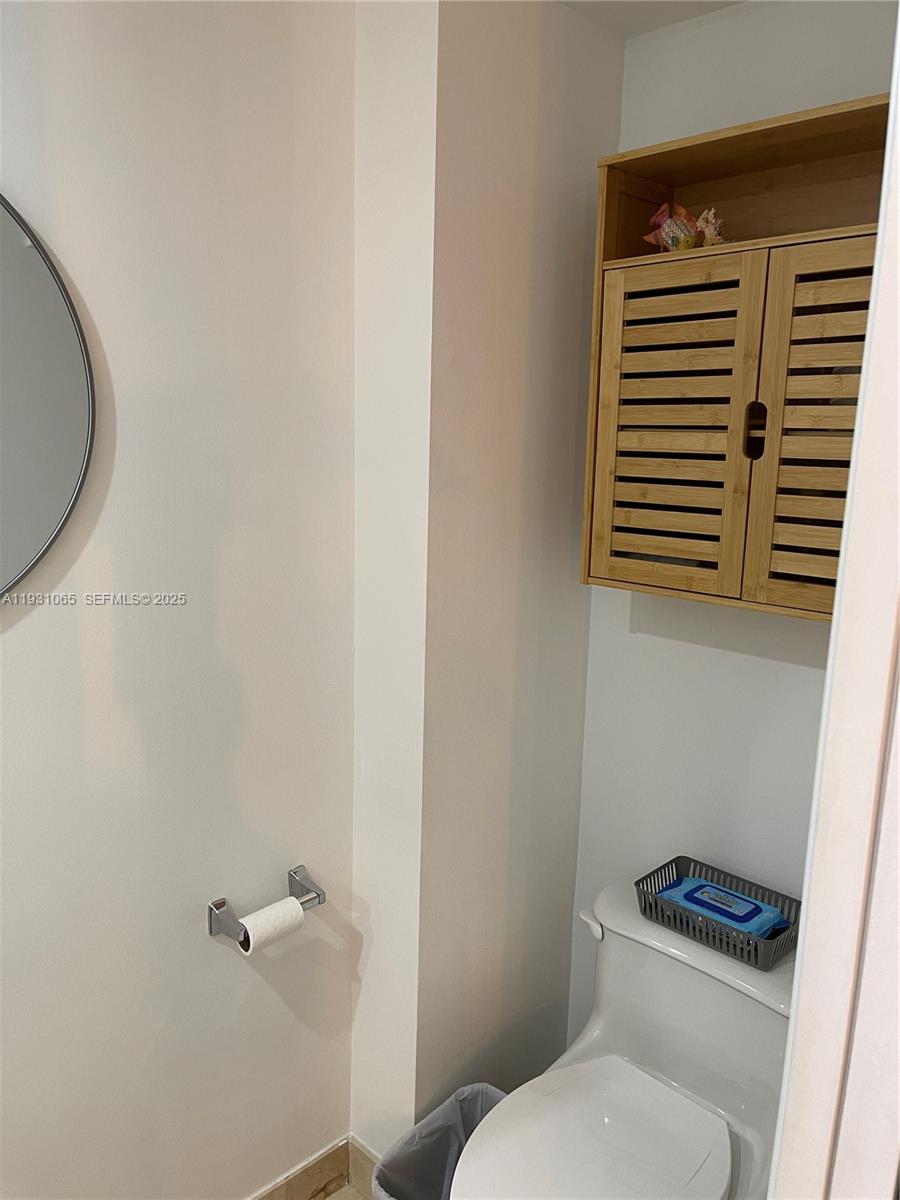 6917 Collins Avenue, Unit 1008 Miami Beach, FL 33141 - Photo 21 of 64 a white toilet sitting next to a bathroom sink