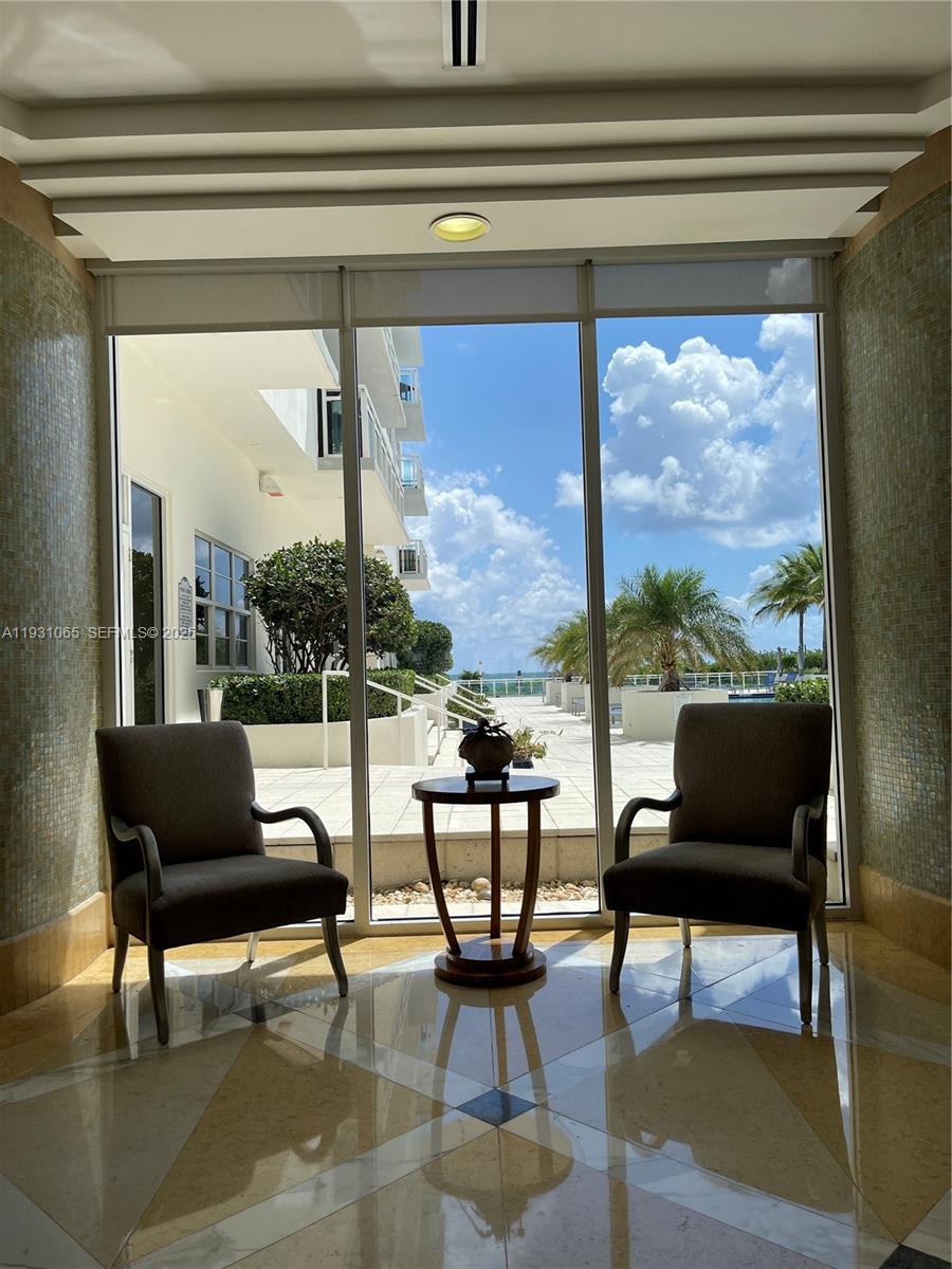 6917 Collins Avenue, Unit 1008 Miami Beach, FL 33141 - Photo 23 of 64 a living room with furniture and a floor to ceiling window