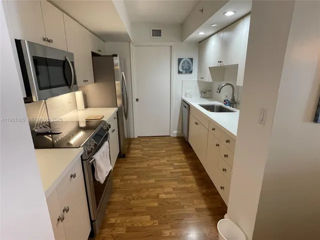 a table with a stove and white cabinets