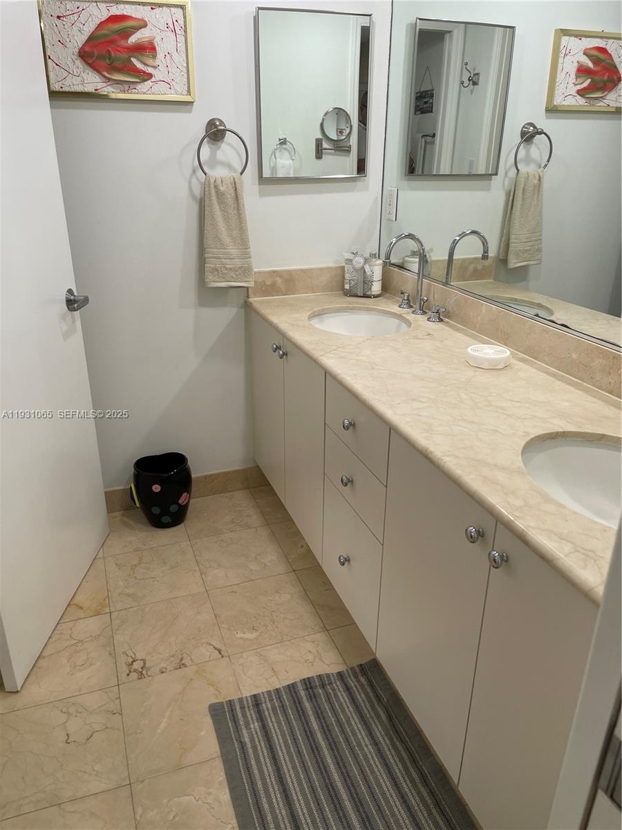 6917 Collins Avenue, Unit 1008 Miami Beach, FL 33141 - Photo 47 of 64 a bathroom with a sink and a mirror