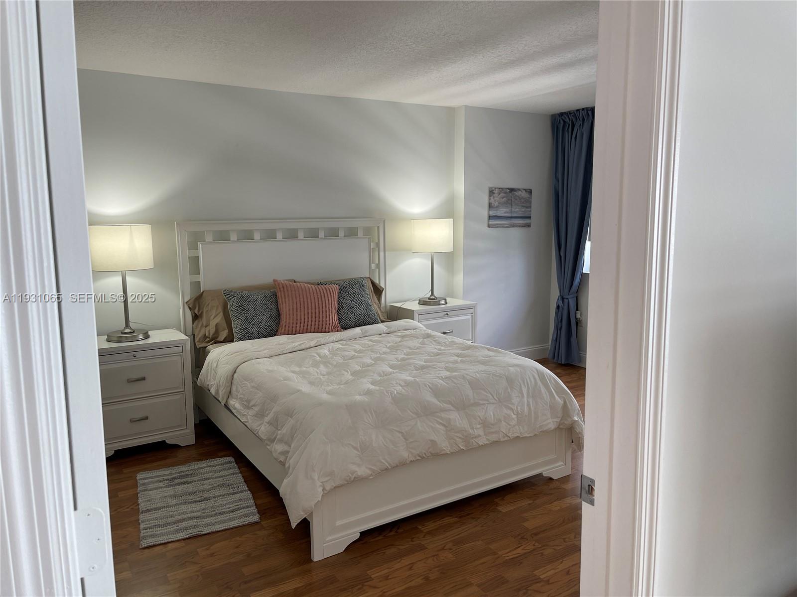 6917 Collins Avenue, Unit 1008 Miami Beach, FL 33141 - Photo 49 of 64 a bedroom with a bed and a night stand